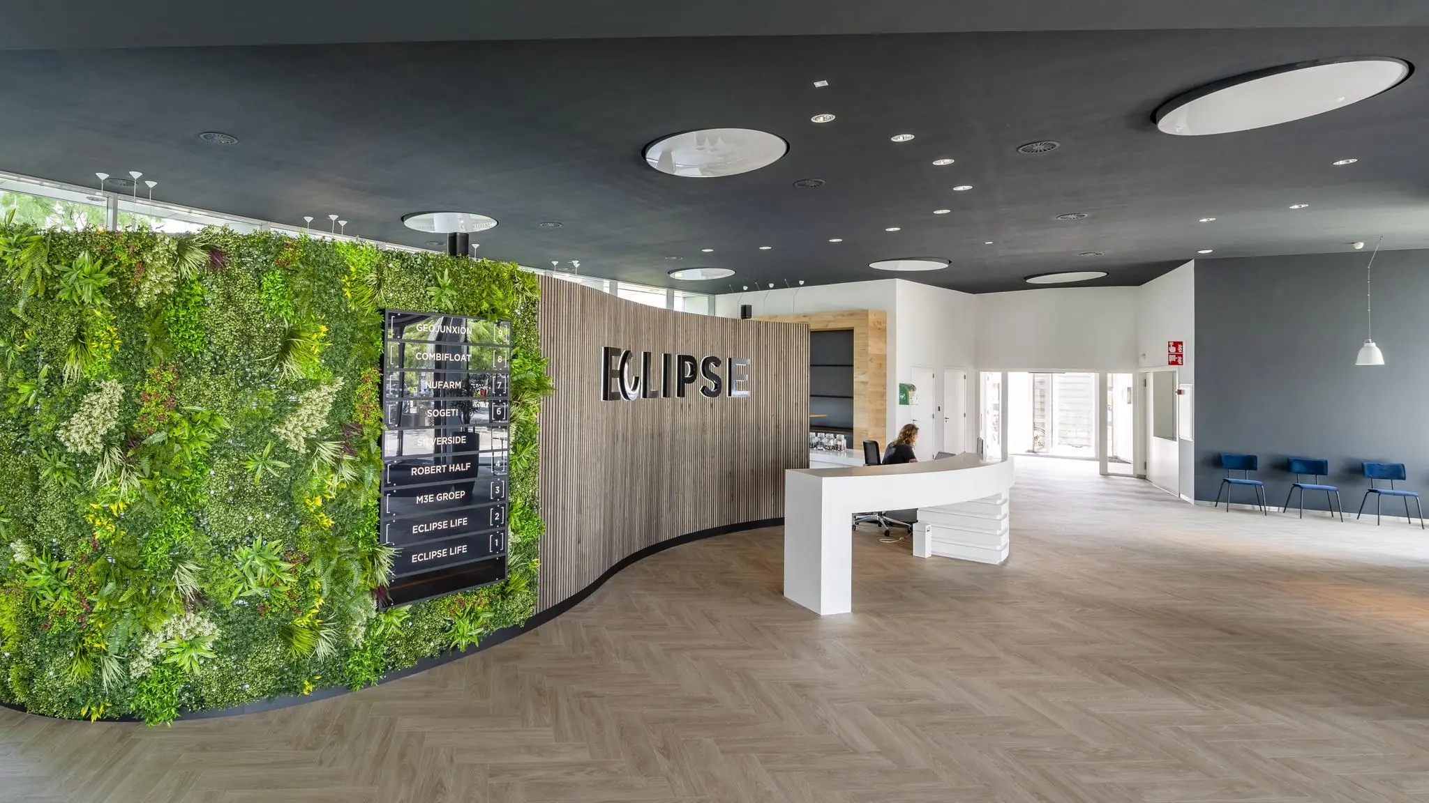 Moderne ontvangsthal van het Eclipse-gebouw in Rivium Quadrant met een groene plantenwand en receptiebalie.
